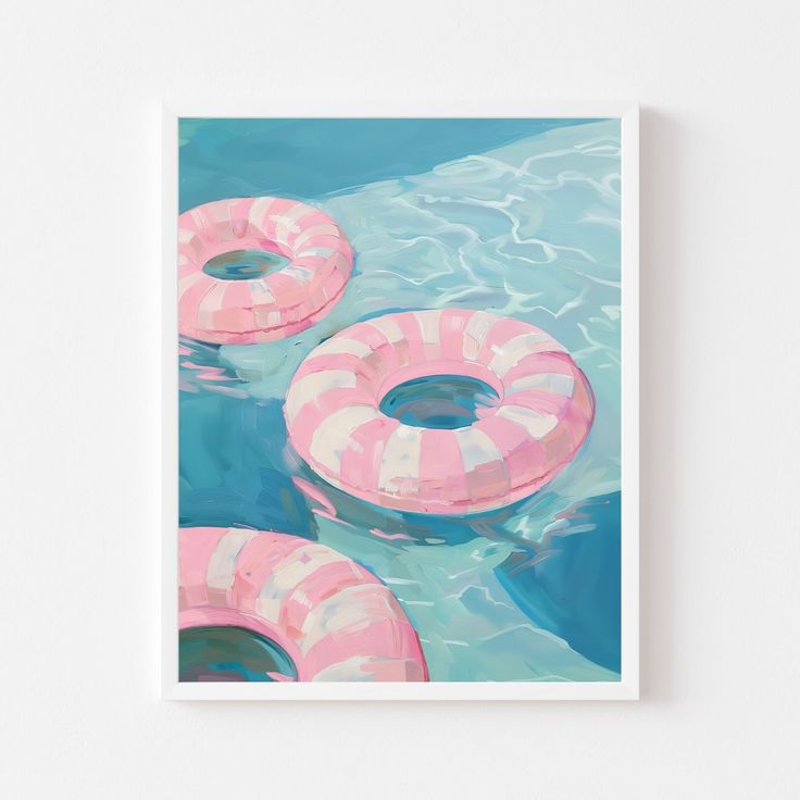 three pink and white inflatable floats floating on the blue water with ripples