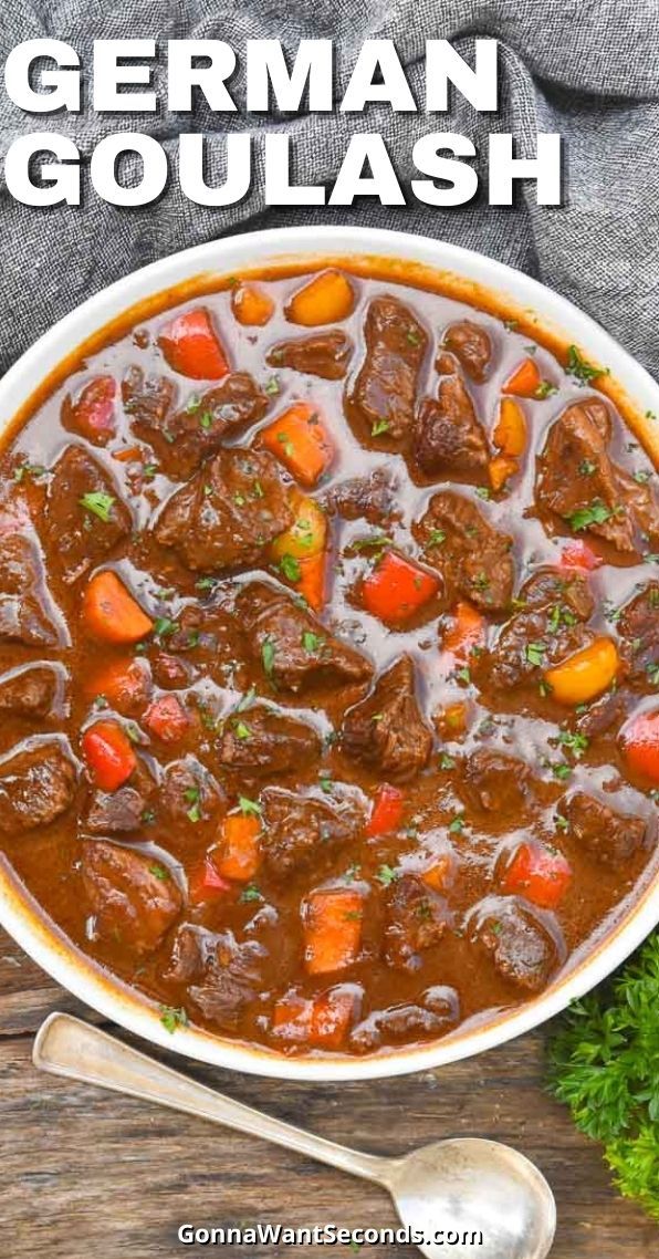 a bowl of beef stew with carrots and parsley