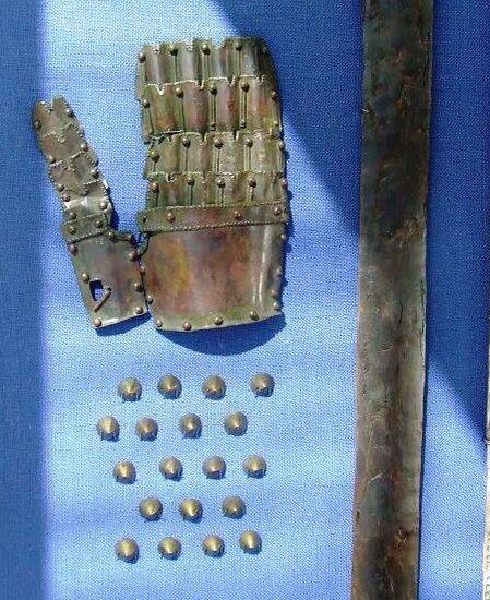 an old pair of gloves and some metal balls on a blue cloth with holes in it