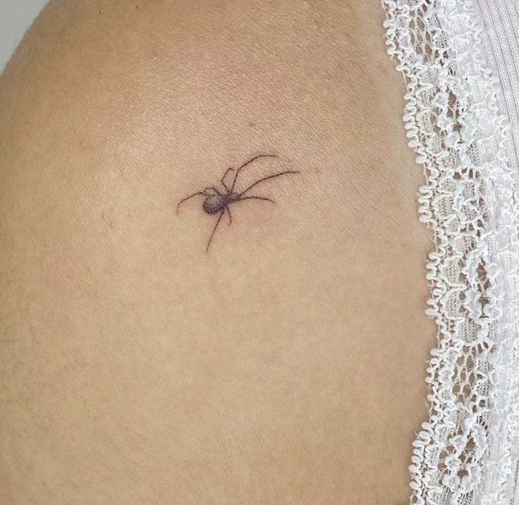 a small spider tattoo on the back of a woman's stomach