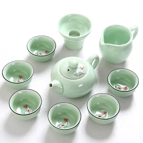 a tea set with cups and saucers on a white table top next to each other