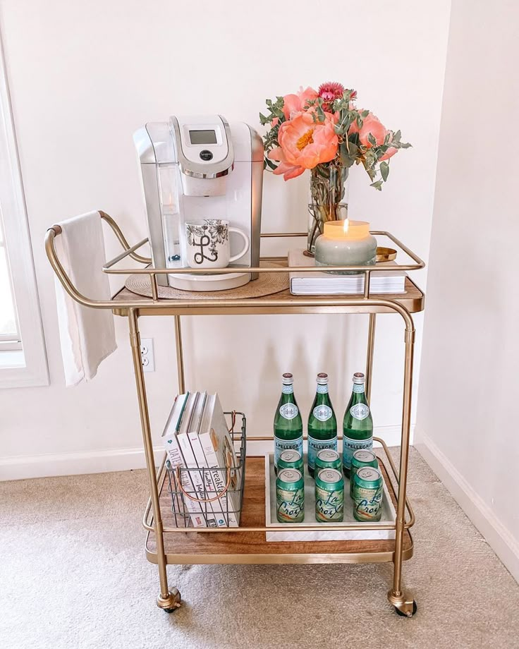 a gold bar cart with drinks on it and a coffee maker next to the top shelf