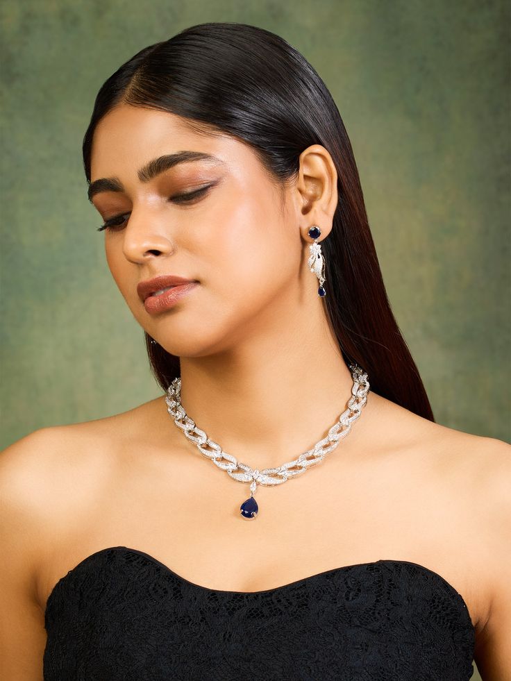 Elevate your elegance with the Regal Radiance Royal Blue Sapphire CZ Necklace Set. This stunning collection features brilliant royal blue sapphire with cubic zirconias, their deep, mesmerizing hue reminiscent of a twilight sky. Each CZ is meticulously crafted to capture and reflect light with an enchanting sparkle, enhancing the set’s overall luminosity. The necklace's design showcases these dazzling gems in a sophisticated arrangement, creating a visual symphony of royal blue brilliance. Comple Twilight Sky, Cz Necklace, Showcase Design, Necklace Designs, Matching Earrings, Necklace Set, Blue Sapphire, Royal Blue, Choker Necklace