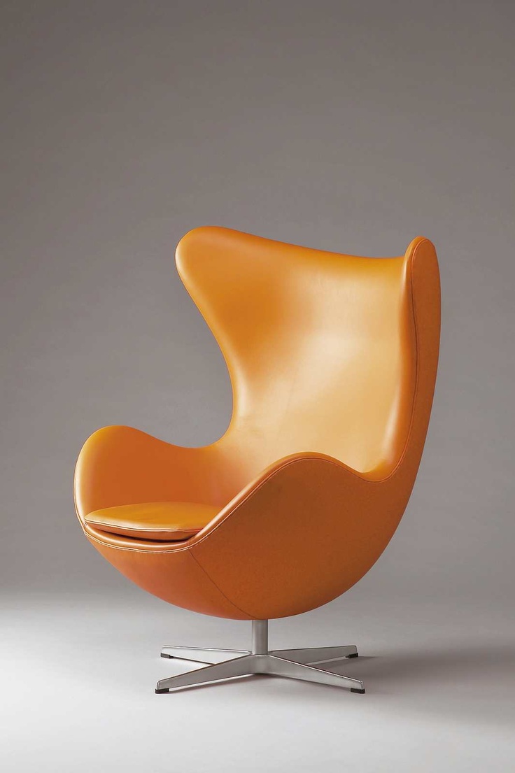 an orange egg chair sitting on top of a metal base