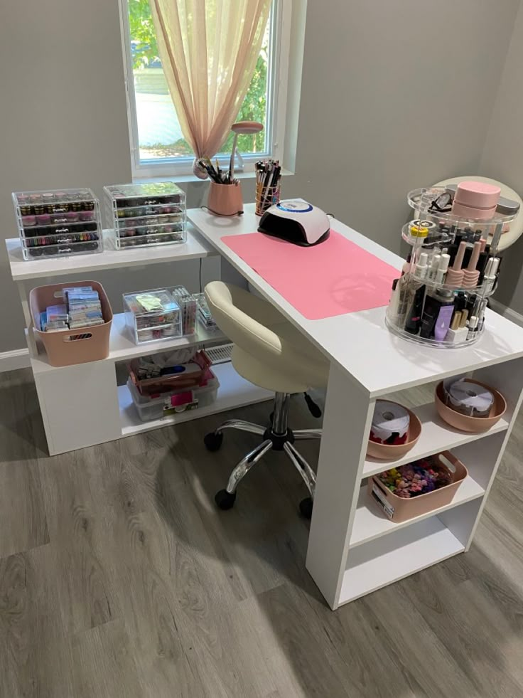 a desk with lots of crafting supplies on it in front of a window,