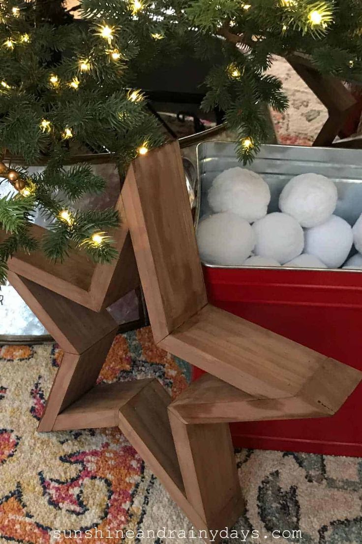 a christmas tree with white balls in it and a wooden star decoration on the top