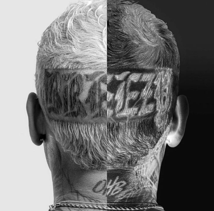 the back of a man's head with tattoos on his face and neck area