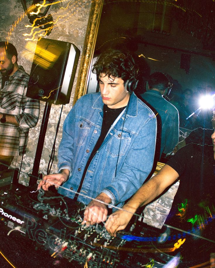 a dj mixing music at a party with other people