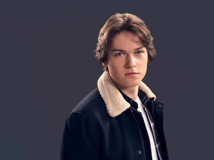 a young man in a black jacket and white shirt