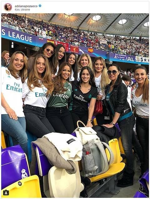 a group of women standing next to each other in front of a stadium full of people