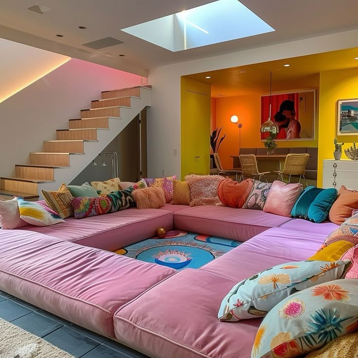 a living room filled with lots of furniture and colorful pillows on top of the couch