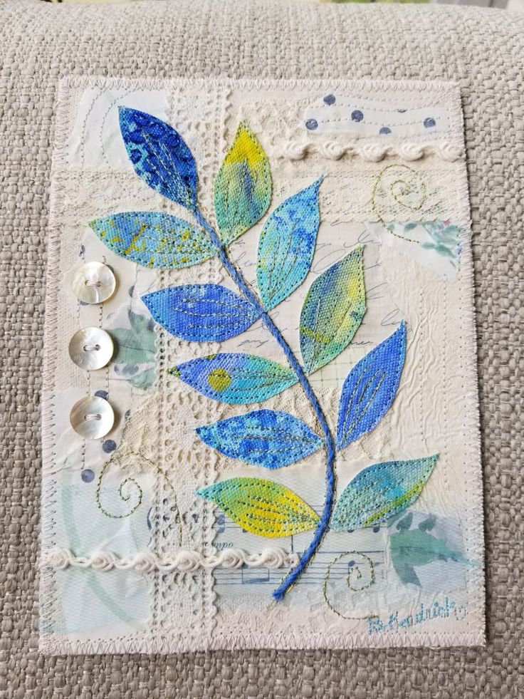 a close up of a pillow with buttons on it and a plant painted on the side