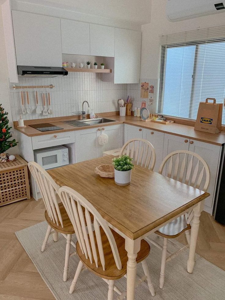 a kitchen table with four chairs and a potted plant on top of the table