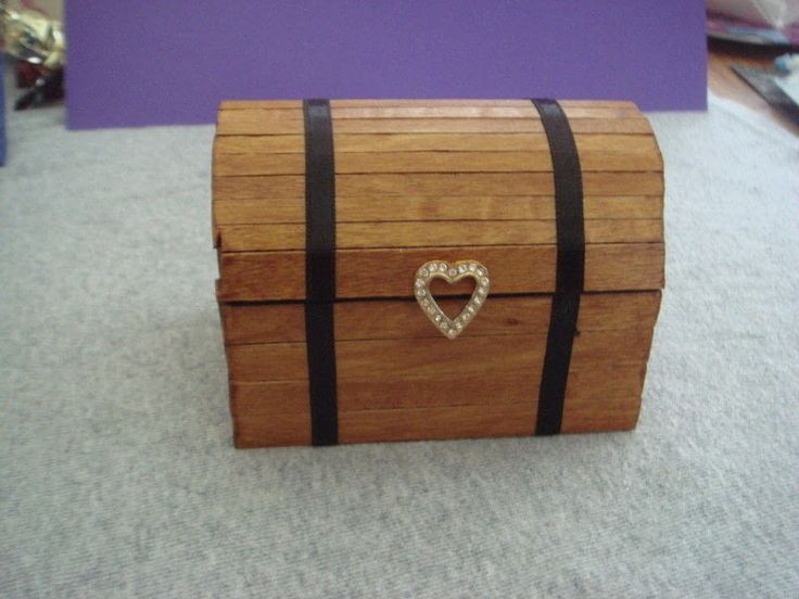 a wooden box sitting on top of a carpeted floor next to a purple wall