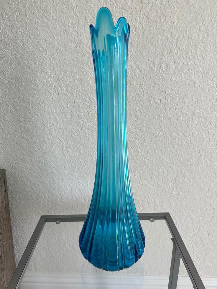 a blue vase sitting on top of a glass table