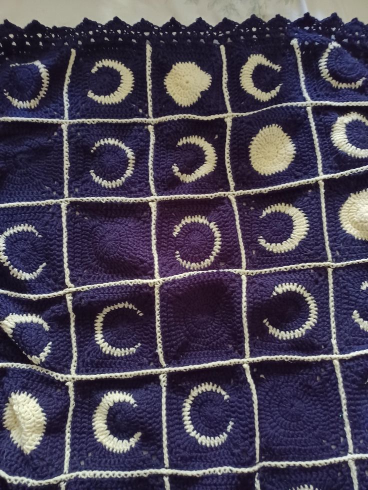 a crocheted blanket with white circles on it