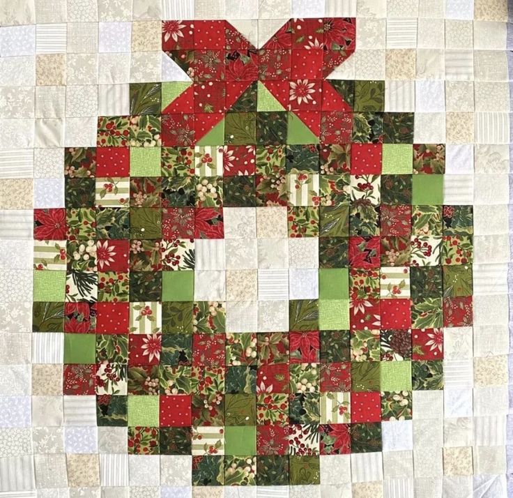 a quilted christmas ornament with red, green and white squares