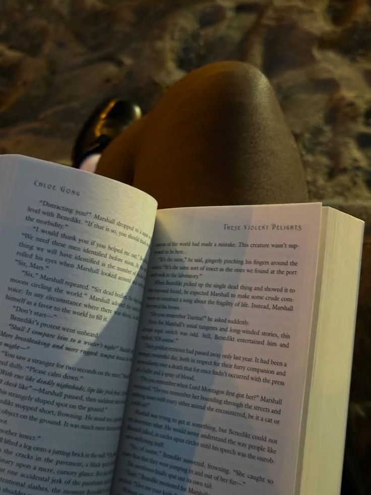 an open book sitting on top of a person's legs