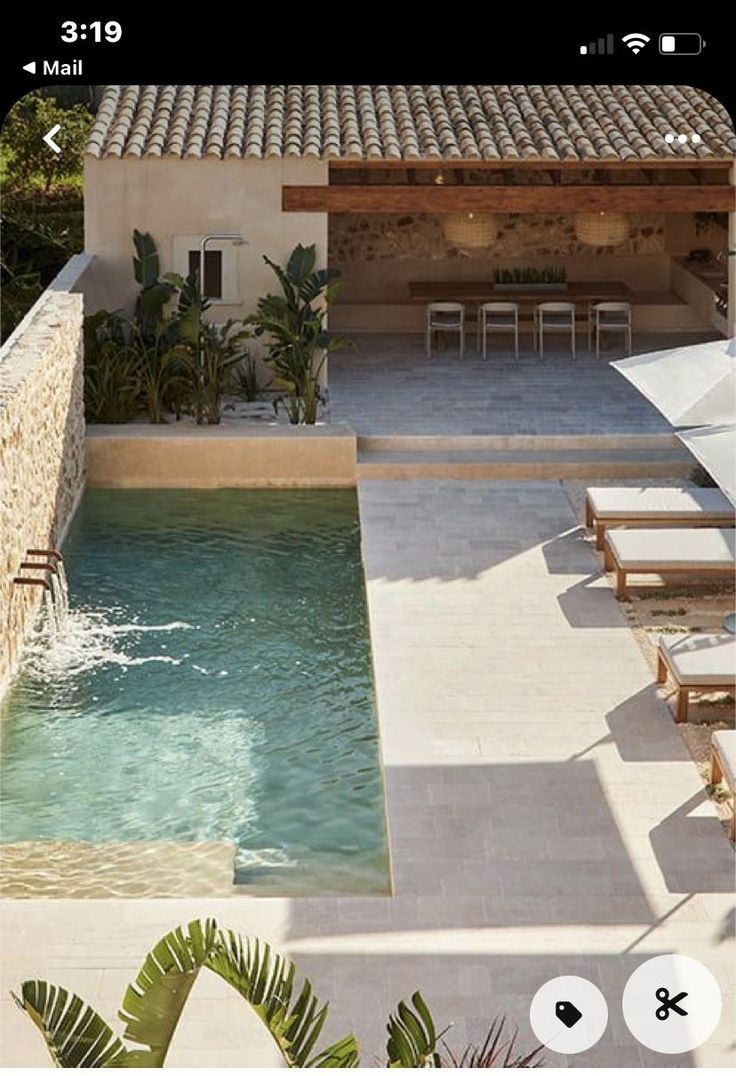 an outdoor swimming pool with chairs and umbrellas