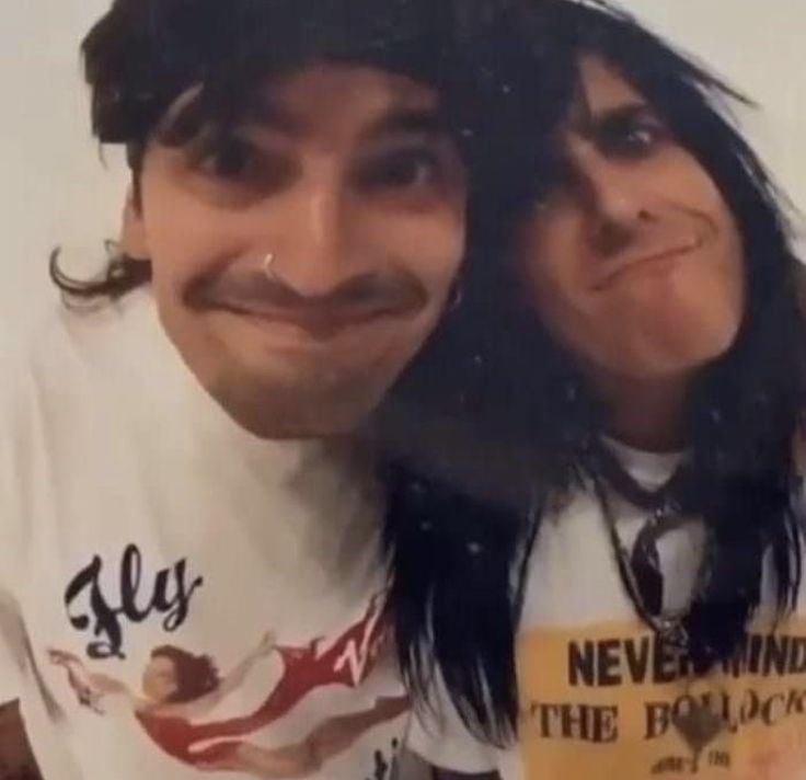 two people with long hair and piercings posing for the camera