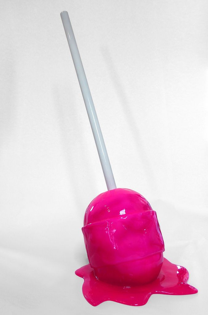 a pink object with a white stick sticking out of it's side on a white background