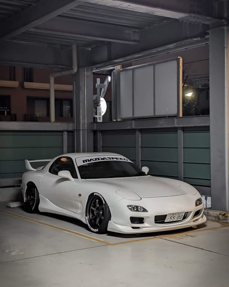 a white sports car parked in a parking garage