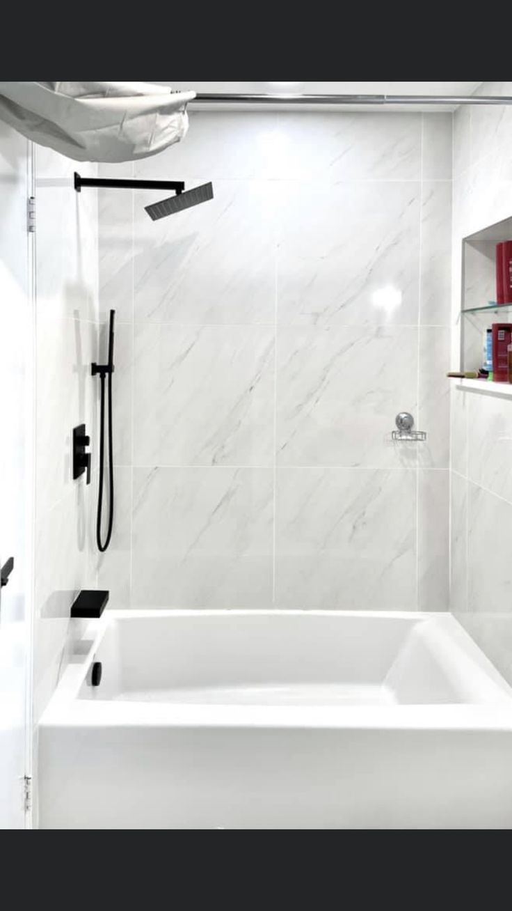 a bathroom with a white tub and black shower faucet next to the bathtub