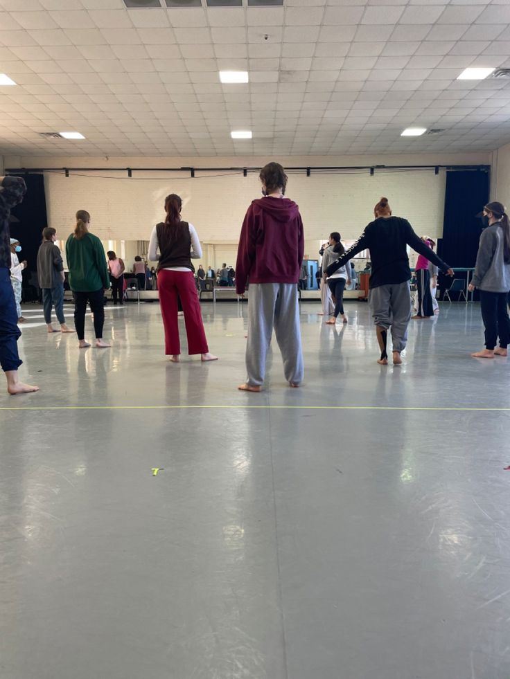 a group of people standing on top of a white floor next to each other in a room