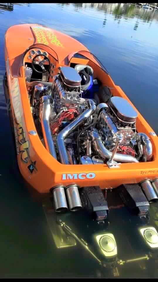 an orange boat with two engines in the water