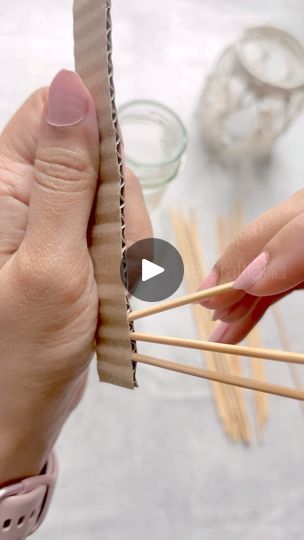 two hands holding chopsticks and an object in front of them