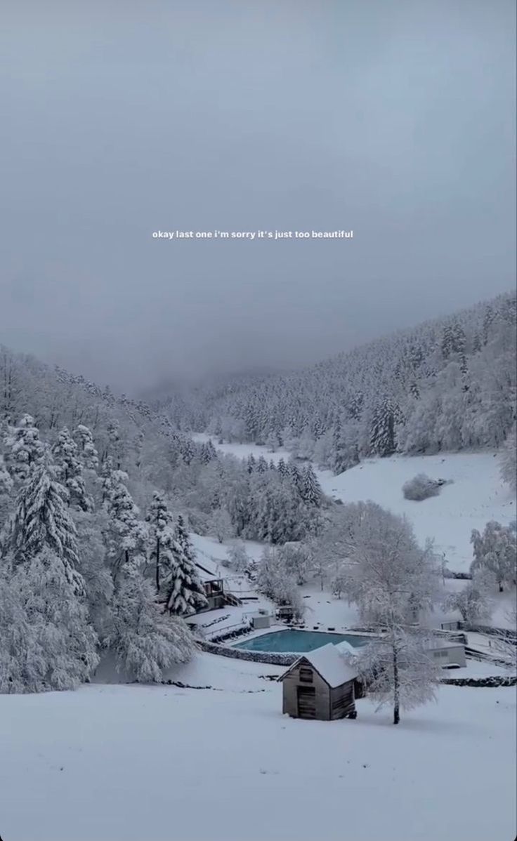 a snowy landscape with trees and a house in the foreground, surrounded by snow covered mountains