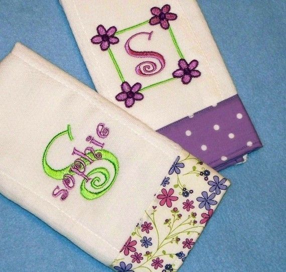 three embroidered napkins with numbers and flowers on them