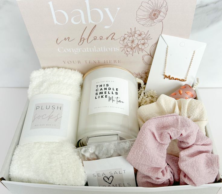 the baby in bloom congratulations gift box is filled with personal care items, such as a candle, socks, and more