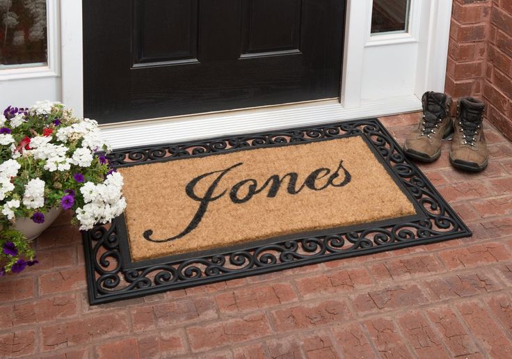 a door mat with the word jones on it next to flowers and potted plants