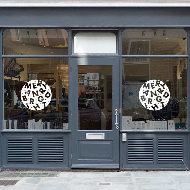 a store front with two circular cutouts on the glass door and one sign that says men's books