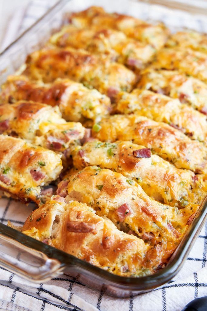 a casserole dish with ham and cheese in it sitting on a tablecloth