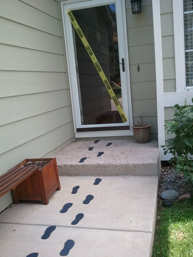 the front door is taped with tape and there are footprints painted on the concrete outside