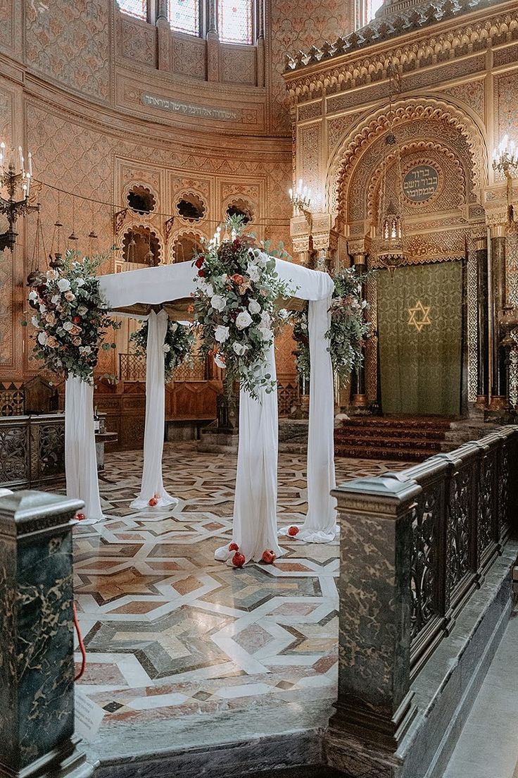 the interior of a church decorated with white and red flowers