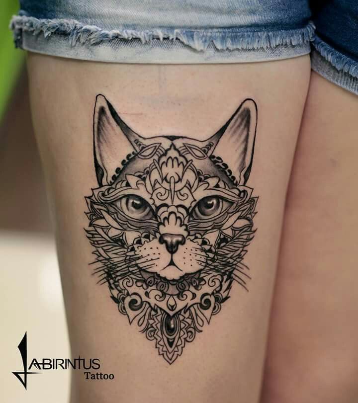 a woman's thigh with a cat tattoo on it