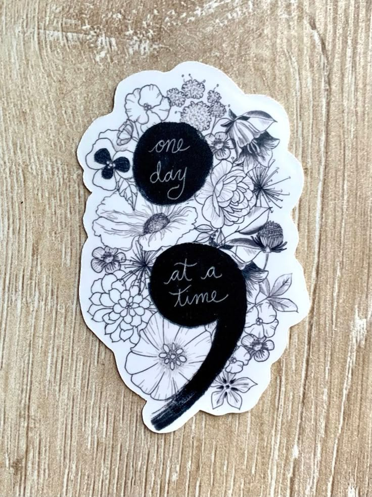 a sticker that says one day at a time with flowers and butterflies on it