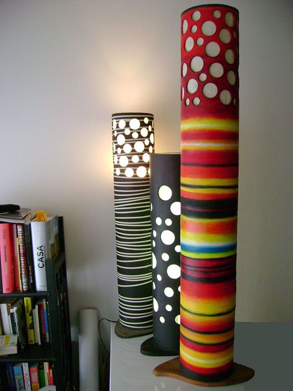 three different colored vases sitting on top of a table next to a book shelf