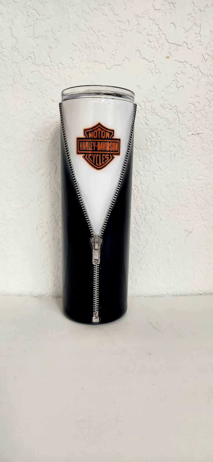 a black and white cup with a zipper on the bottom that says harley davidson cycles