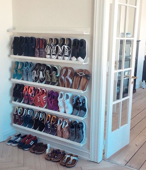 there are many pairs of shoes on the shelves in this room and one is open