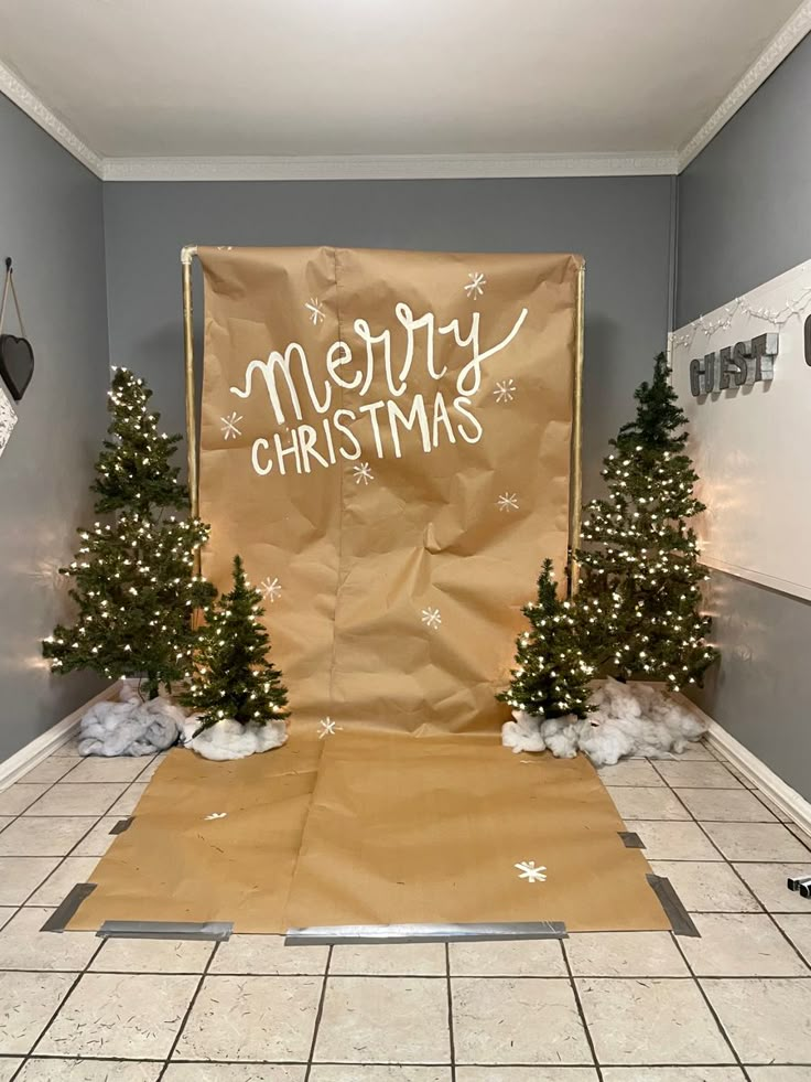 a room with christmas decorations on the floor and a sign that says merry christmas in front of it