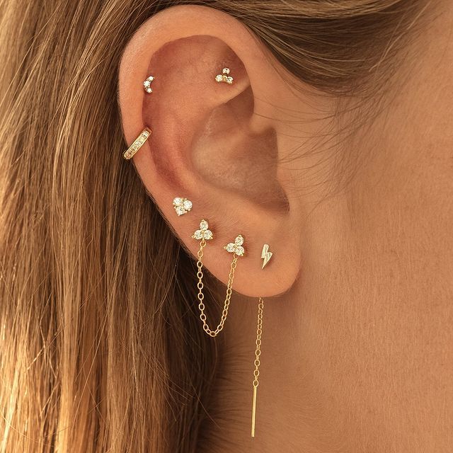 a close up of a person's ear with three different piercings on it