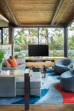 a living room filled with furniture and a flat screen tv on top of a wooden ceiling