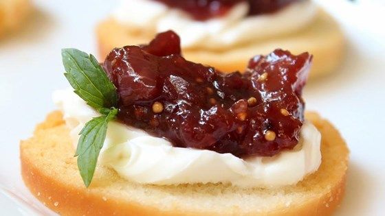 small crackers with jam and whipped cream on them