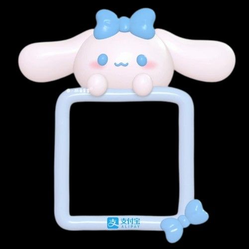 a white and blue stuffed animal on top of a small photo frame with a black background