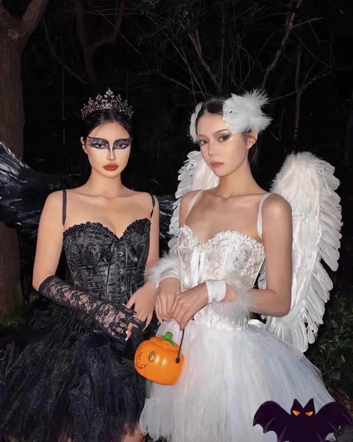 two women dressed in halloween costumes standing next to each other with pumpkins on their hands