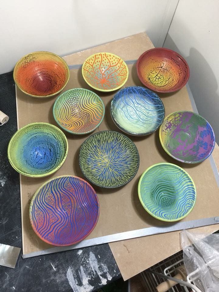 many different colored bowls are sitting on the table